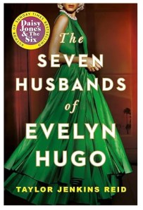 Showing the front cover of the book The Seven Husbands of Evelyn Hugo by Taylor Jenkins Reid, this image has the book title and author’s name on it overlaid onto an image of a blonde, glamorous woman wearing a green, sleeveless ball dress. The woman is shown side on and you can only see the lower half of her face.